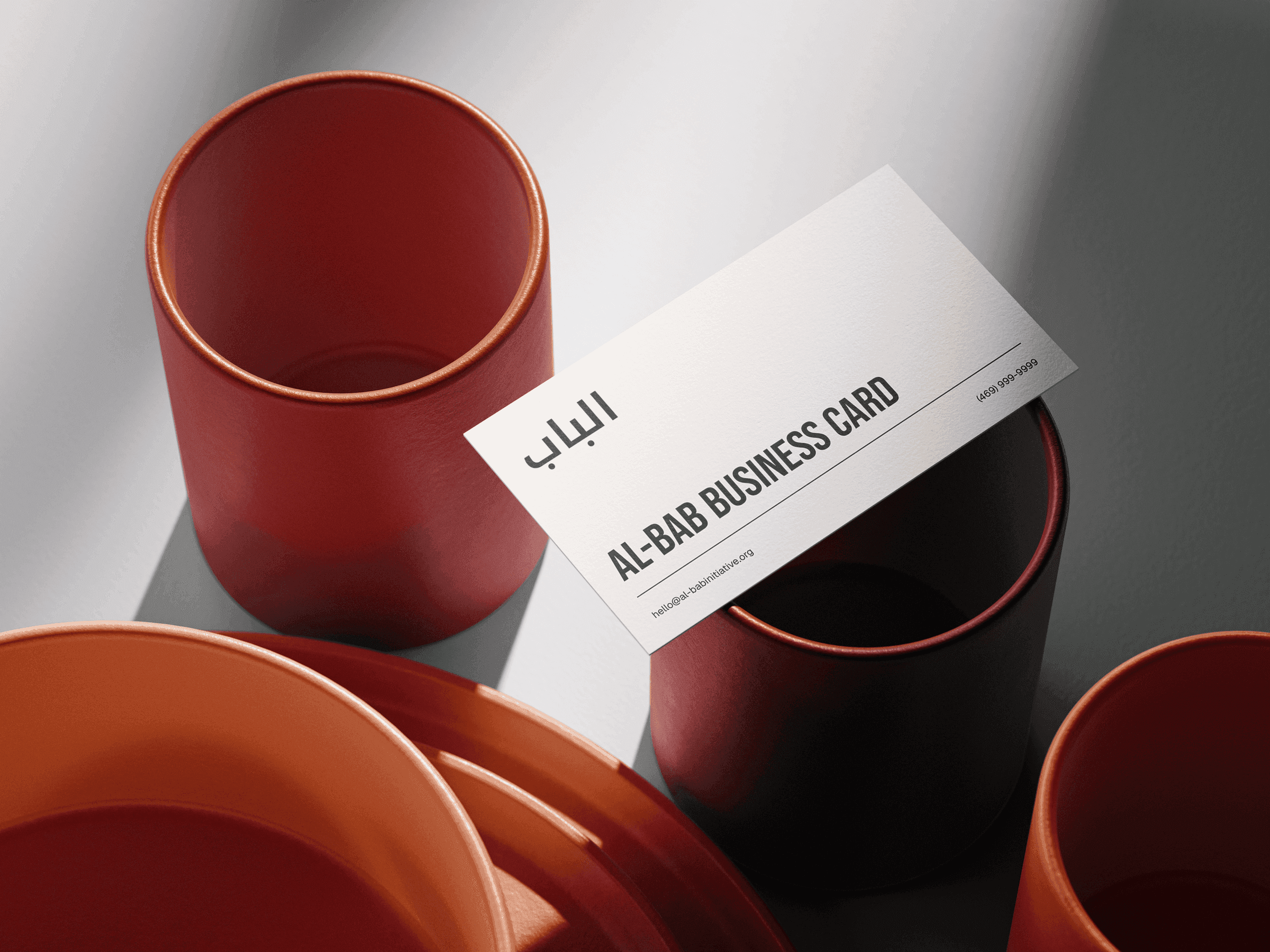 Al-Bab Initiative business cards photographed on a textured surface.